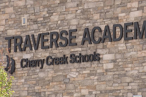 The words Traverse Academy mounted on the side of a stone-walled building