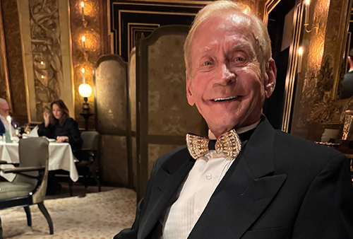 Dr. Terry Larsen in a suit and bowtie smiles at the camera